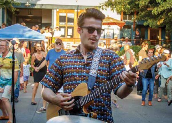 A musician plays guitar at a street festival on Whidbey Island